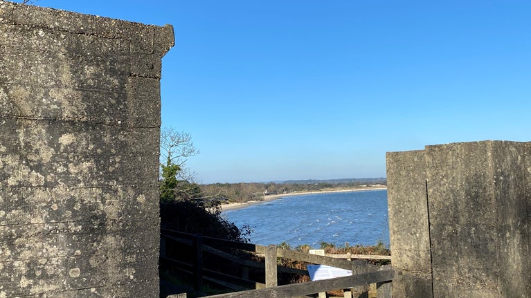 Two concrete wartime bunkers with blue sea beyond.